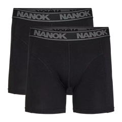 Billedet viser en dobbelpakke sorte boxershorts med længere ben og en bred elastiklinning prydet af det grå 'NANOK'-logo. Designet er enkelt og tidløst med flade syninger og formskærende paneler, der signalerer god støtte og komfort. Stoffet fremstår blødt og smidigt, velegnet til både hverdag og aktivitet. Et praktisk og stilrent valg til underdelen.