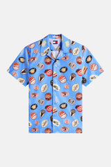 Chemise bleue à manches courtes de TOMMY JEANS, ornée d'un motif d'images ressemblant à des autocollants de fruits.
