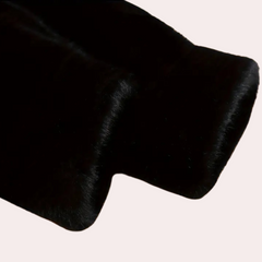 Svart pelsstoff, nærbilde av tekstur. Myk, luksuriøs overflate, ideell for mote og interiørdesign. Høy kvalitet, elegant materiale.